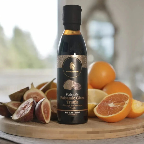 Balsamic Glaze Truffle bottle on a wooden board with oranges and figs.