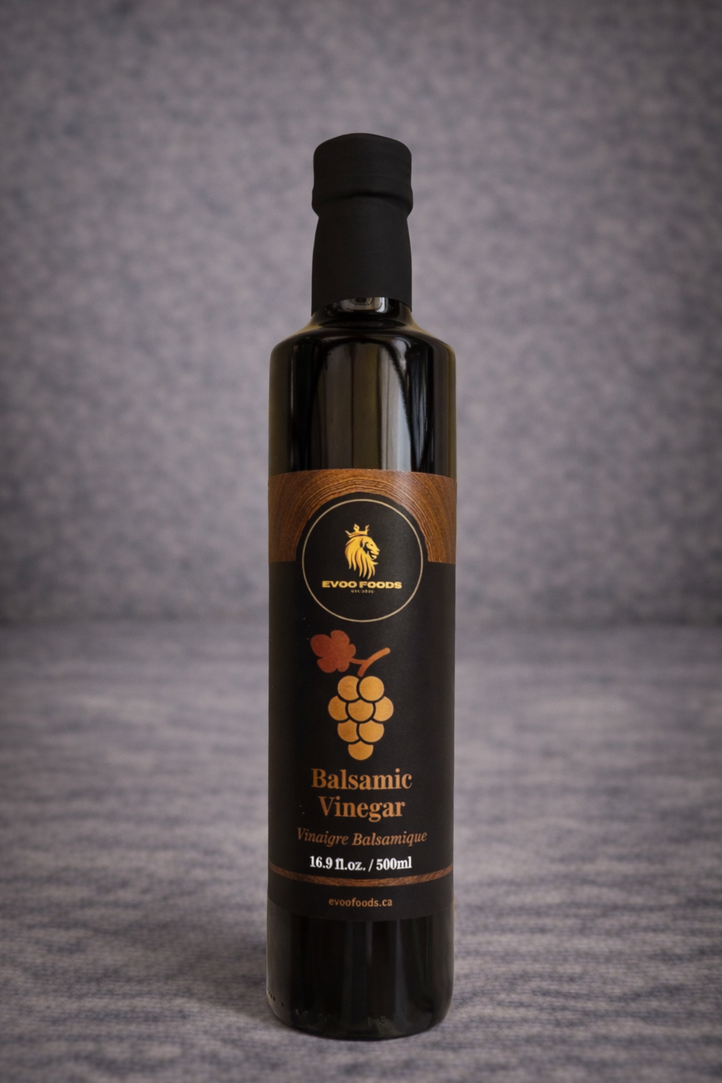 Bottle of balsamic vinegar with a label on a gray background