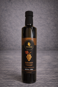 Bottle of balsamic vinegar with a label on a gray background