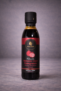 Bottle of Balsamic Glaze Pomegranate on a wooden surface with a gray background