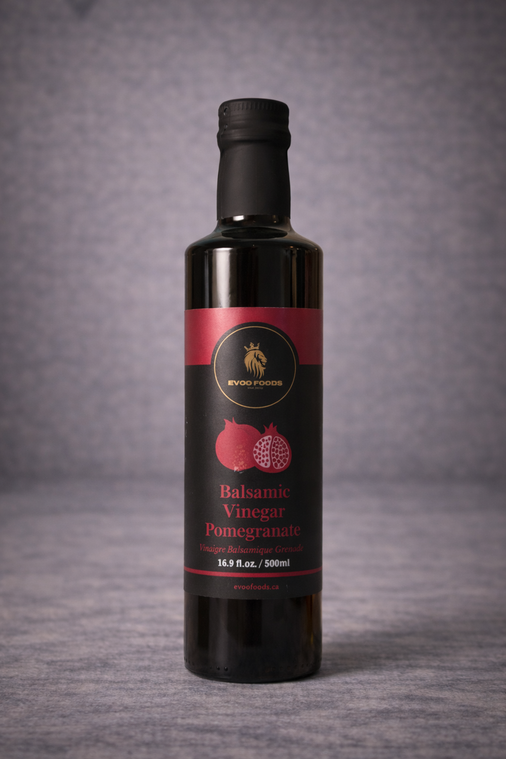 Bottle of balsamic vinegar with pomegranate flavor on a gray background