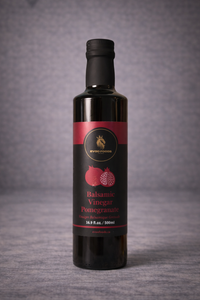 Bottle of balsamic vinegar with pomegranate flavor on a gray background