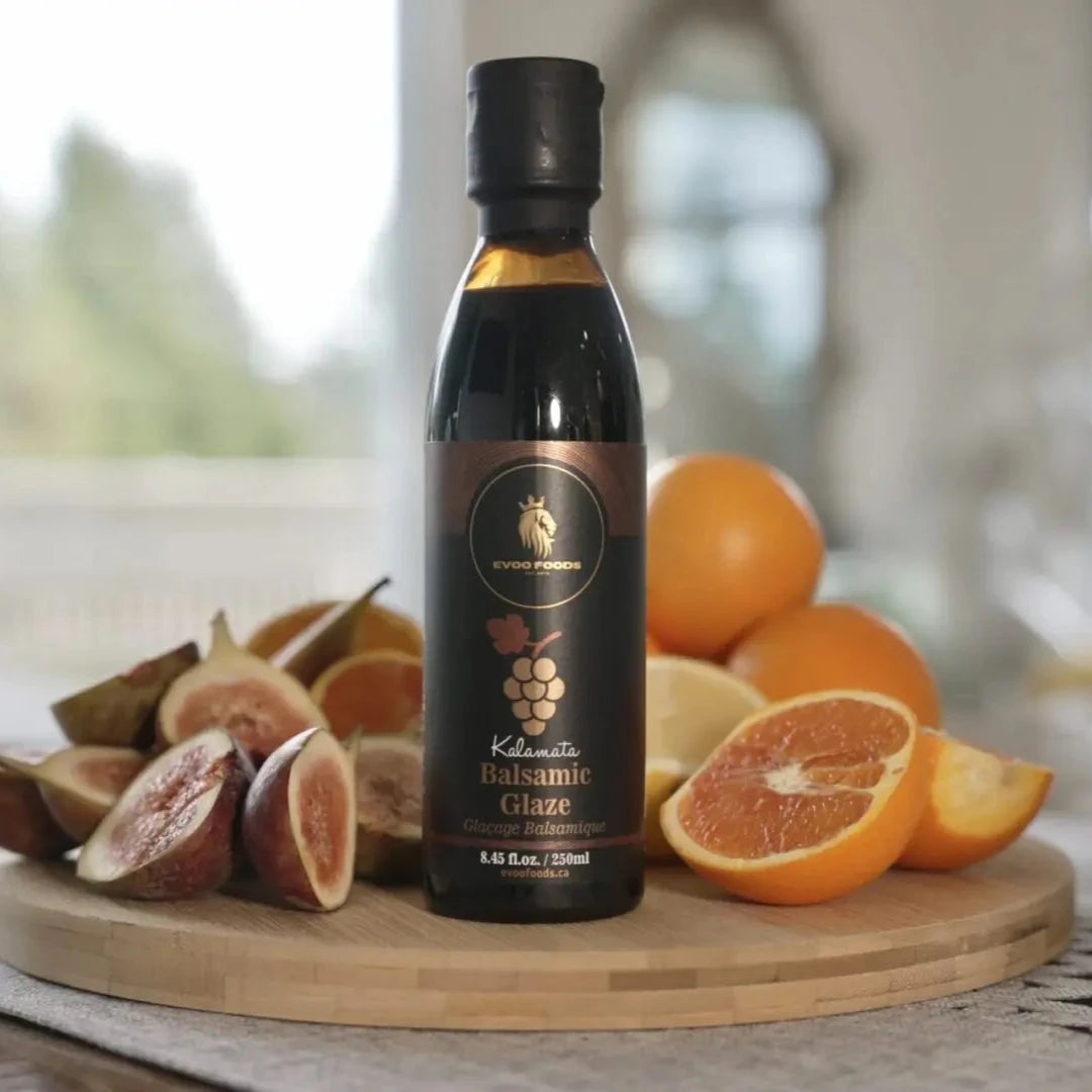 Bottle of Kalamata Balsamic Glaze on a wooden board with fruits in a bright setting